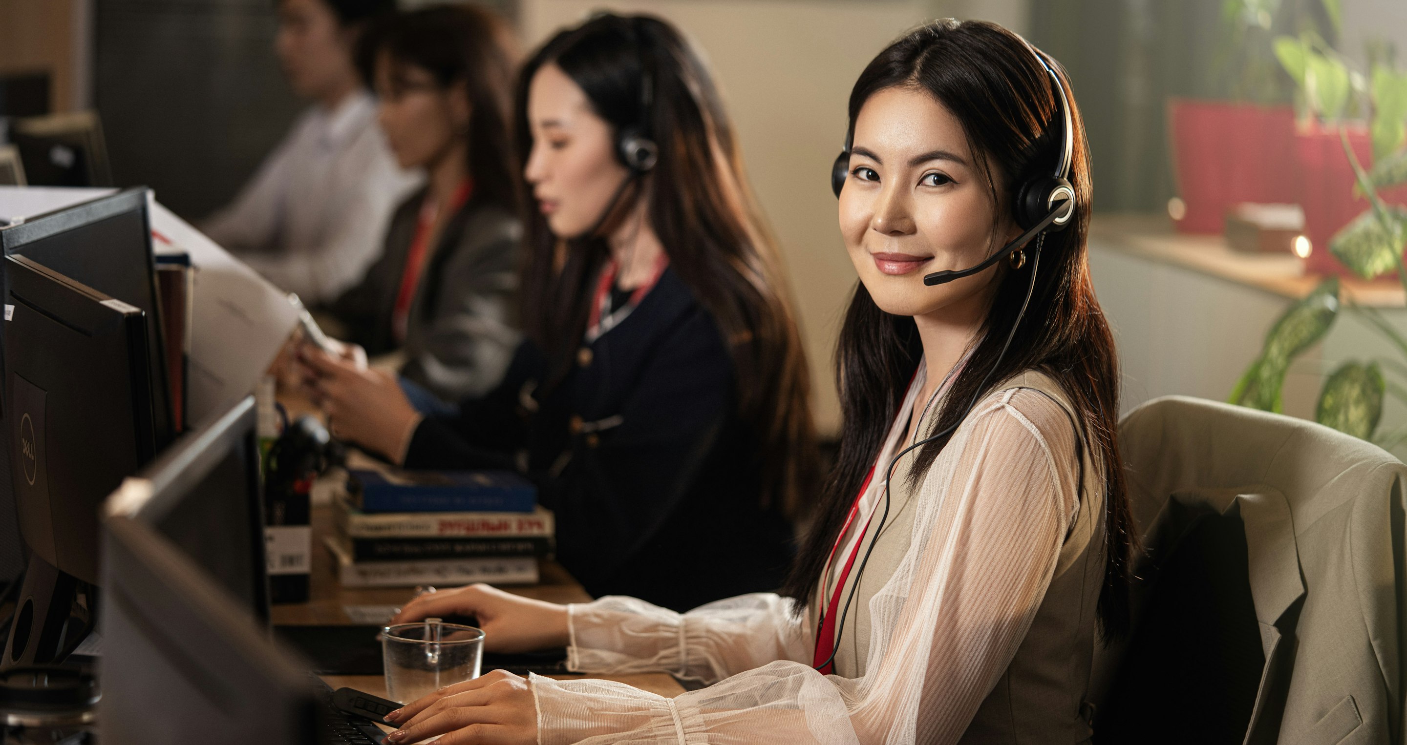 Call centre agents wearing headsets at their workstations